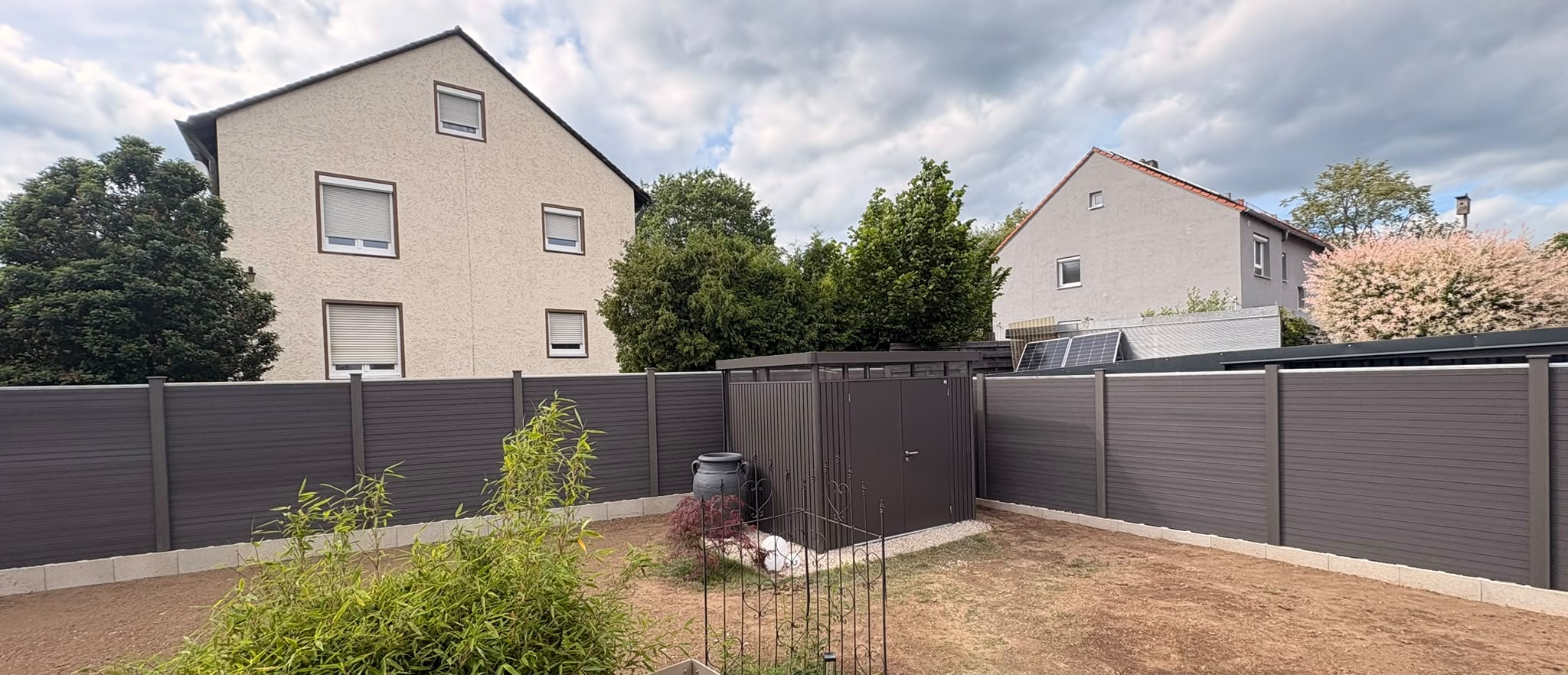 Garten nach dem Zaunbau mit neuem WPC-Sichtschutzzaun